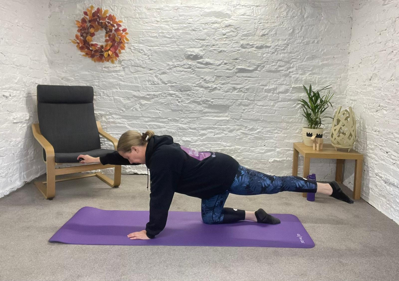Rebecca is demonstrating a pilates pose from her virtual pilates studio, The Wellness Barn.